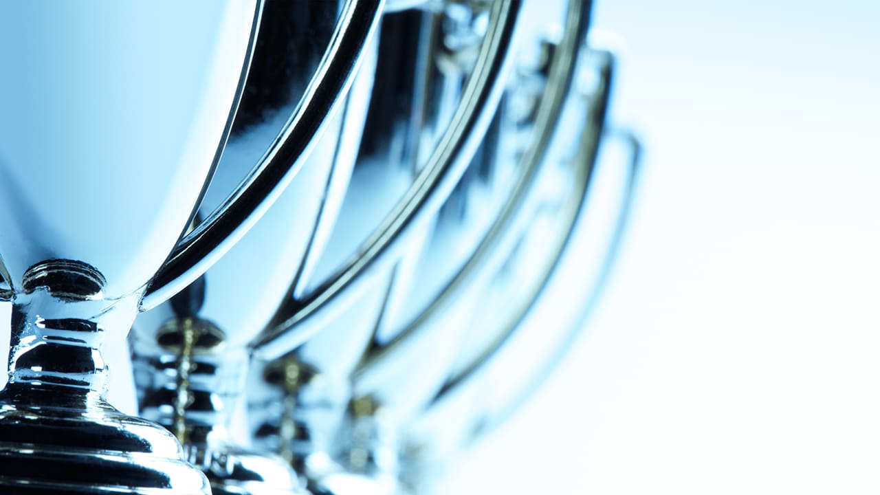 A group of trophies set against a blue background